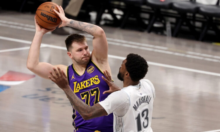 Luka Dončić looks to pass for the Los Angeles Lakers as Naji Marshall defends for the Dallas Mavericks during the fourth quarter at American Airlines Center