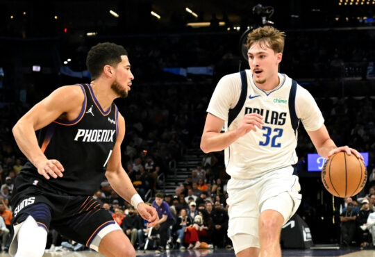 NBA: Cooper Flagg dribbles the ball for the Dallas Mavericks while defended by Devin Booker of the Phoenix Suns at Mortgage Matchup Center.