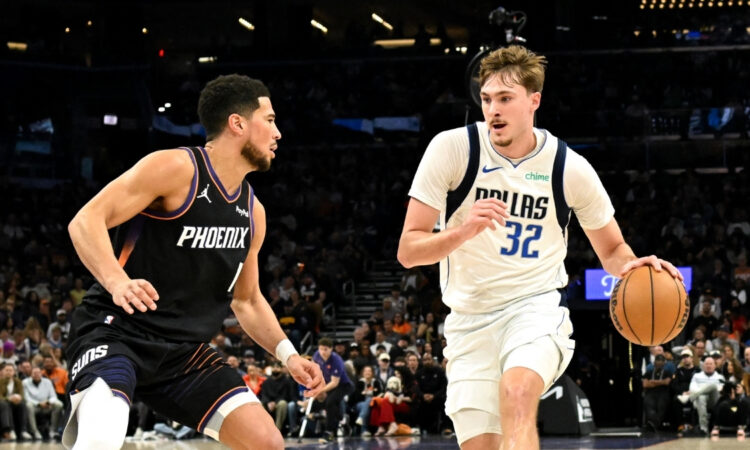 NBA: Cooper Flagg dribbles the ball for the Dallas Mavericks while defended by Devin Booker of the Phoenix Suns at Mortgage Matchup Center.