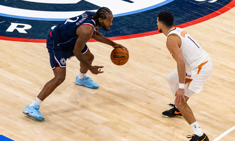 Phoenix Suns guard Devin Booker guards Los Angeles Clippers forward Kawhi Leonard