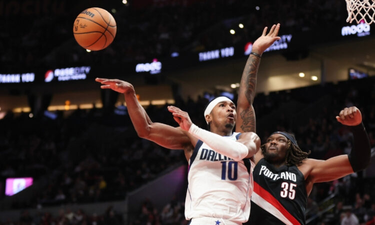 Brandon Williams of the Dallas Mavericks passes away from Robert Williams III of the Portland Trail Blazers during the fourth quarter at Moda Center on December 29, 2025.