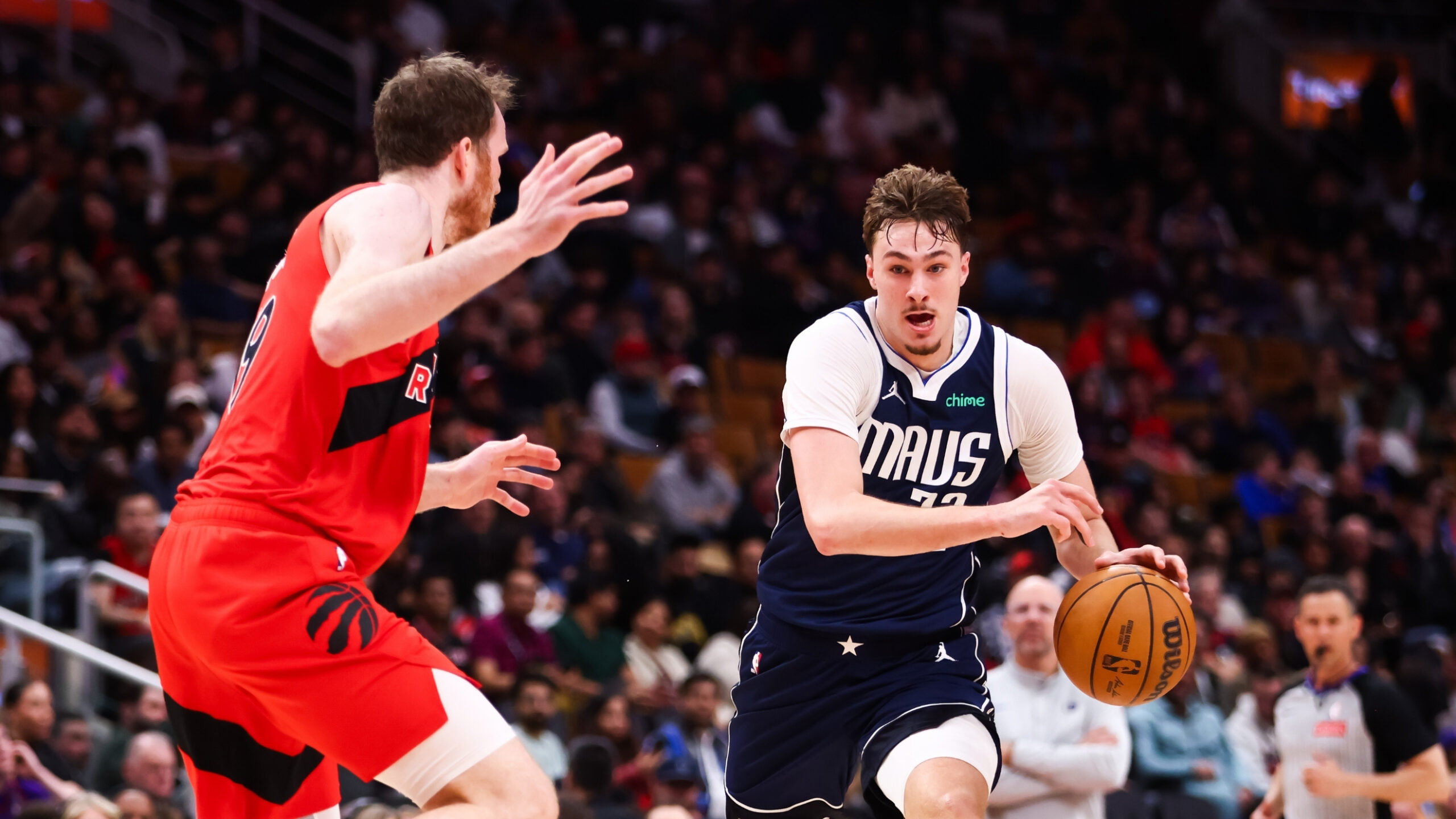 Cooper Flagg #32 of the Dallas Mavericks drives to the basket against Jakob Poeltl #19 of the Toronto Raptors at Scotiabank Arena on March 8, 2026.