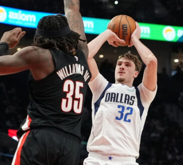 Cooper Flagg of the Dallas Mavericks shoots over Robert Williams III of the Portland Trail Blazers during the first half at Moda Center on March 27, 2026.