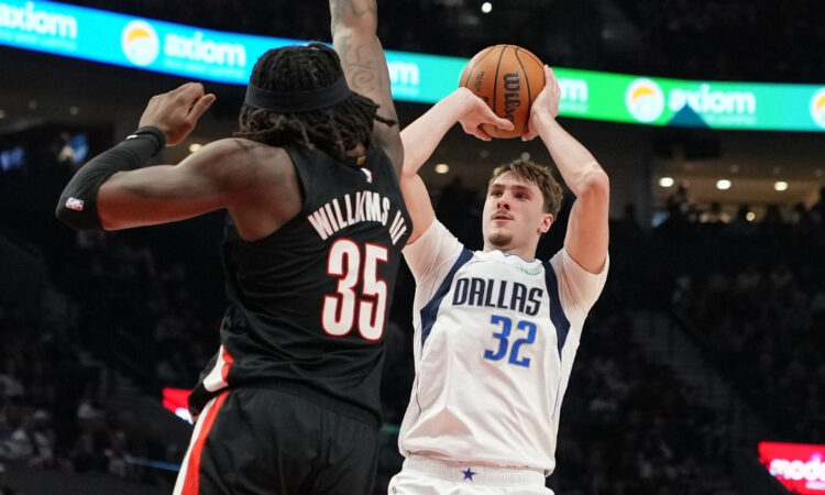 Cooper Flagg of the Dallas Mavericks shoots over Robert Williams III of the Portland Trail Blazers during the first half at Moda Center on March 27, 2026.