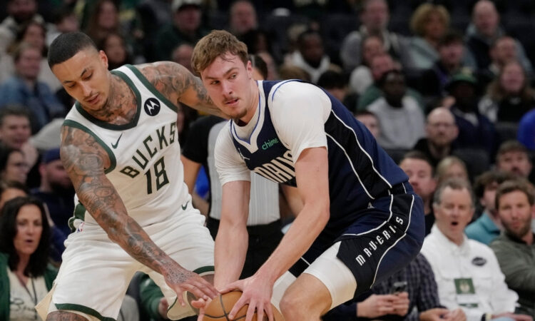 Cooper Flagg #32 of the Dallas Mavericks attempts a steal against Kyle Kuzma #18 of the Milwaukee Bucks during the first quarter at Fiserv Forum.