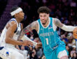 NBA: LaMelo Ball brings the ball up court for the Charlotte Hornets while guarded by Brandon Williams of the Dallas Mavericks during a game at Spectrum Center.