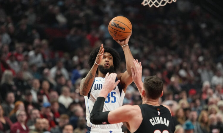 Marvin Bagley III #35 of the Dallas Mavericks shoots a jumper over Donovan Clingan #23 of the Portland Trail Blazers at Moda Center.