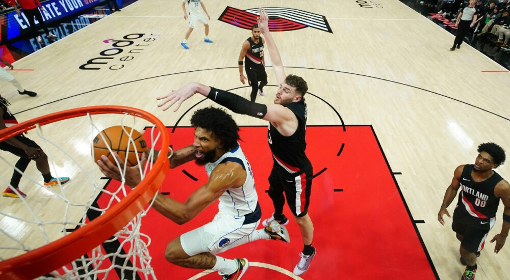 Marvin Bagley III of the Dallas Mavericks attempts a layup defended by Donovan Clingan of the Portland Trail Blazers during the second half at Moda Center on March 27, 2026.