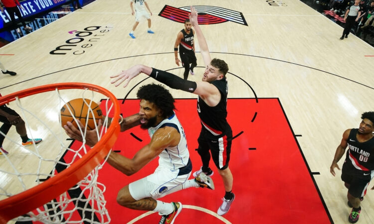 Marvin Bagley III of the Dallas Mavericks attempts a layup defended by Donovan Clingan of the Portland Trail Blazers during the second half at Moda Center on March 27, 2026.