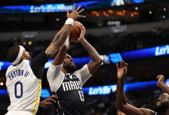 Naji Marshall drives against Gary Payton II and Draymond Green during Mavericks–Warriors overtime on March 23, 2026.