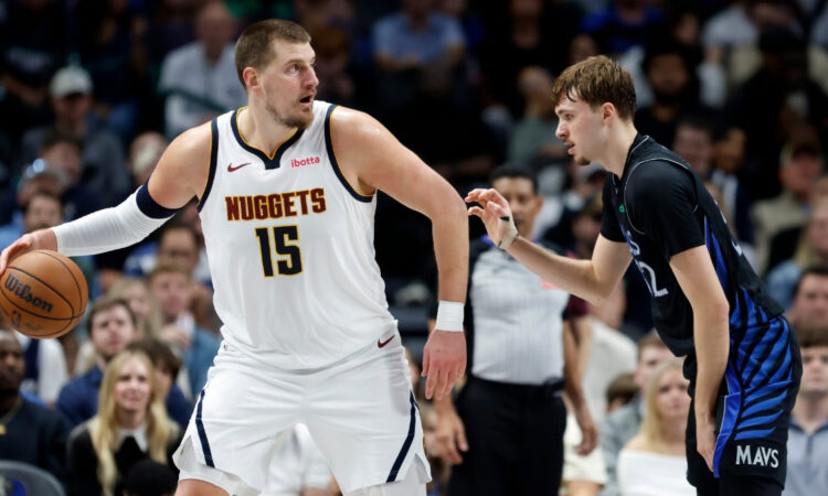 Nikola Jokic of the Denver Nuggets controls the ball while defended by Dallas Mavericks rookie Cooper Flagg during the second half on December 23, 2025 in Dallas.
