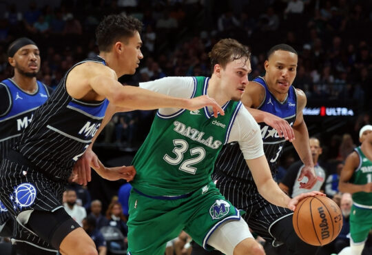 Cooper Flagg #32 of the Dallas Mavericks drives to the basket between Orlando Magic's Tristan da Silva and Desmond Bane during a historic 51-point game at American Airlines Center.