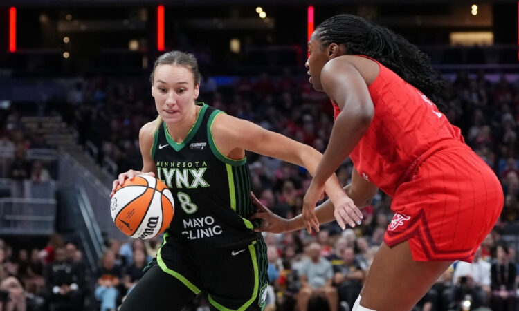 Dallas Wings forward Alanna Smith handling the ball while being guarded by Aliyah Boston of the Indiana Fever at Gainbridge Fieldhouse.