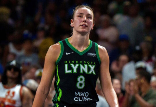 Alanna Smith wearing a Minnesota Lynx jersey walking on the court during a 2025 game against the Atlanta Dream.