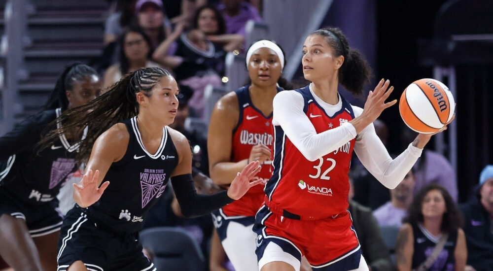 Washington Mystics forward Alysha Clark looks for a passing lane while guarded by Veronica Burton of the Golden State Valkyries.