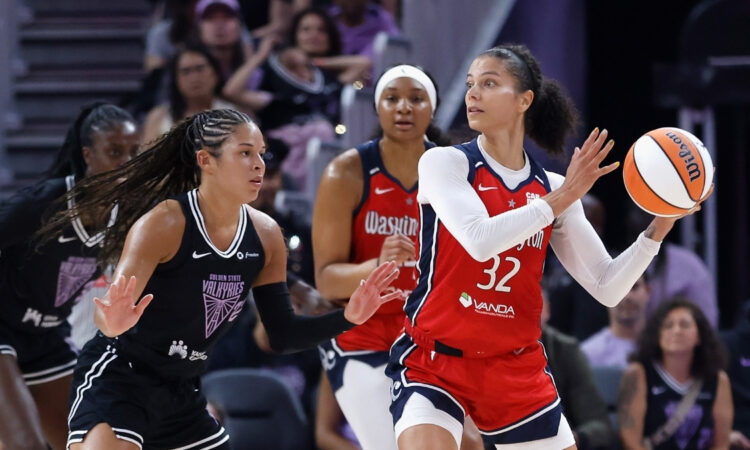Washington Mystics forward Alysha Clark looks for a passing lane while guarded by Veronica Burton of the Golden State Valkyries.