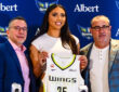 Azzi Fudd holds up her new #35 Dallas Wings jersey alongside General Manager Curt Miller and head coach Jose Fernandez during her introductory press conference in Arlington.
