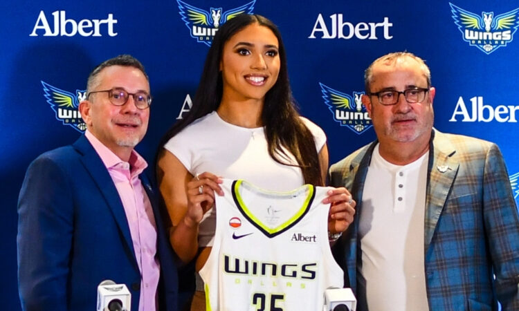 Azzi Fudd holds up her new #35 Dallas Wings jersey alongside General Manager Curt Miller and head coach Jose Fernandez during her introductory press conference in Arlington.