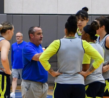 Dallas Wings head coach Jose Fernandez speaks to Paige Bueckers, Alysha Clark, Odyssey Sims, Li Yueru, and Maddy Siegrist during a training camp practice huddle at College Park Center.
