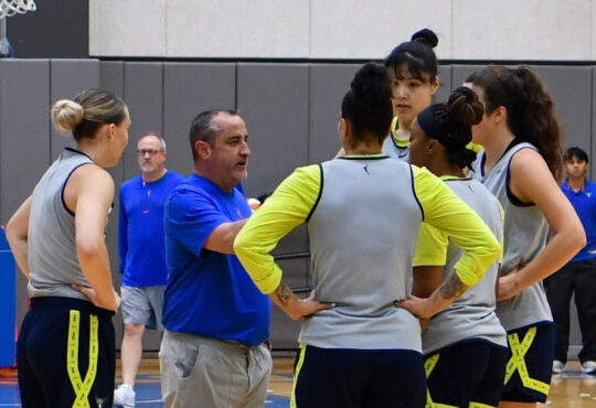 Dallas Wings head coach Jose Fernandez speaks to Paige Bueckers, Alysha Clark, Odyssey Sims, Li Yueru, and Maddy Siegrist during a training camp practice huddle at College Park Center.
