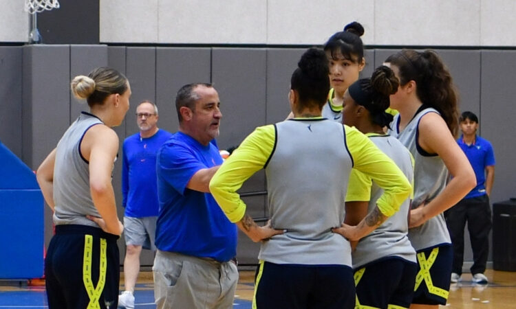 Dallas Wings head coach Jose Fernandez speaks to Paige Bueckers, Alysha Clark, Odyssey Sims, Li Yueru, and Maddy Siegrist during a training camp practice huddle at College Park Center.
