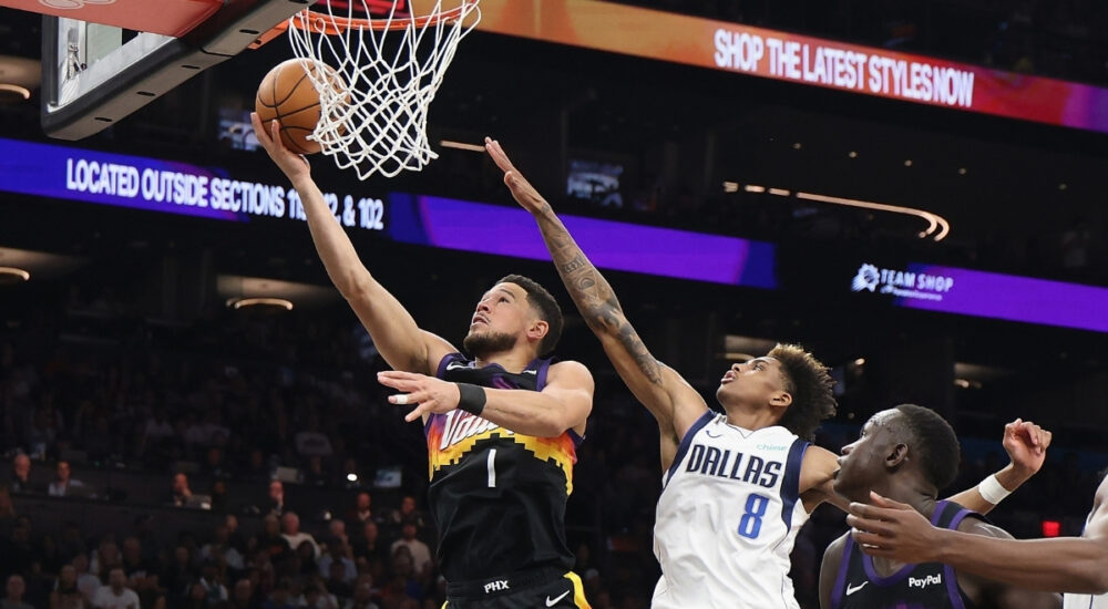 Devin Booker #1 of the Phoenix Suns drives for a layup against AJ Johnson #8 of the Dallas Mavericks during the first half in Phoenix.