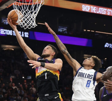 Devin Booker #1 of the Phoenix Suns drives for a layup against AJ Johnson #8 of the Dallas Mavericks during the first half in Phoenix.