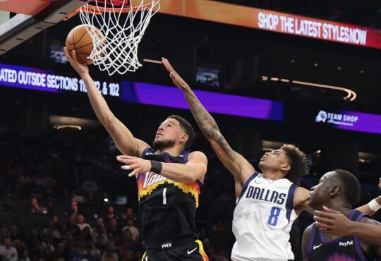 Devin Booker #1 of the Phoenix Suns drives for a layup against AJ Johnson #8 of the Dallas Mavericks during the first half in Phoenix.