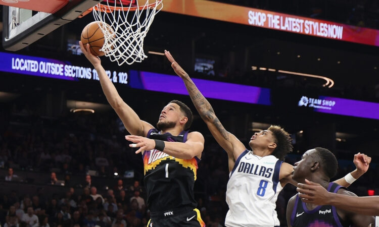 Devin Booker #1 of the Phoenix Suns drives for a layup against AJ Johnson #8 of the Dallas Mavericks during the first half in Phoenix.