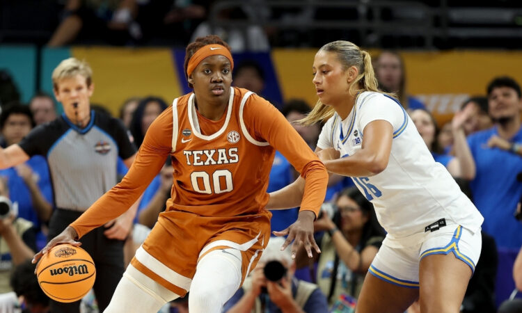 Kyla Oldacre #00 of the Texas Longhorns drives to the basket against Sienna Betts of the UCLA Bruins during the 2026 NCAA Women's Final Four in Phoenix.