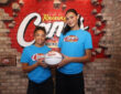 UCLA stars Lauren Betts and Kiki Rice posing with a basketball inside a Raising Cane’s restaurant in Hollywood after winning the 2026 NCAA Championship.