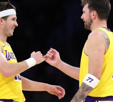 Luka Doncic #77 and Austin Reaves #15 of the Los Angeles Lakers during a timeout against the Chicago Bulls at Crypto.com Arena on March 12, 2026.