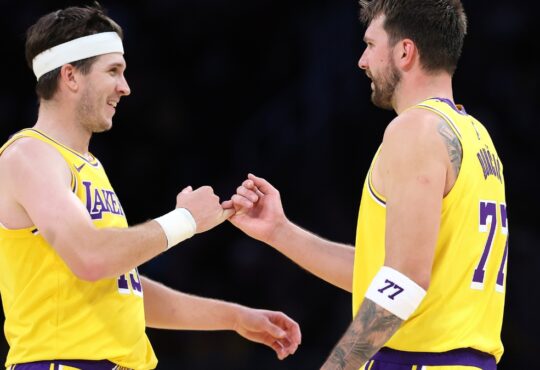 Luka Doncic #77 and Austin Reaves #15 of the Los Angeles Lakers during a timeout against the Chicago Bulls at Crypto.com Arena on March 12, 2026.