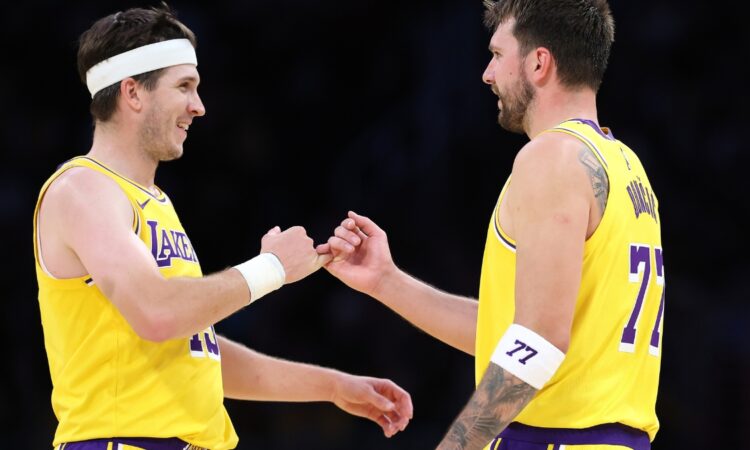 Luka Doncic #77 and Austin Reaves #15 of the Los Angeles Lakers during a timeout against the Chicago Bulls at Crypto.com Arena on March 12, 2026.