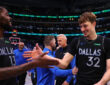 Naji Marshall #13 of the Dallas Mavericks greets Cooper Flagg #32 as they exit the court following a victory over the Los Angeles Lakers at American Airlines Center.