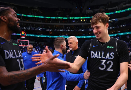 Naji Marshall #13 of the Dallas Mavericks greets Cooper Flagg #32 as they exit the court following a victory over the Los Angeles Lakers at American Airlines Center.