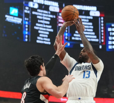 Naji Marshall #13 of the Dallas Mavericks takes a jumper over Deni Avdija #8 of the Portland Trail Blazers during an NBA game at the Moda Center.