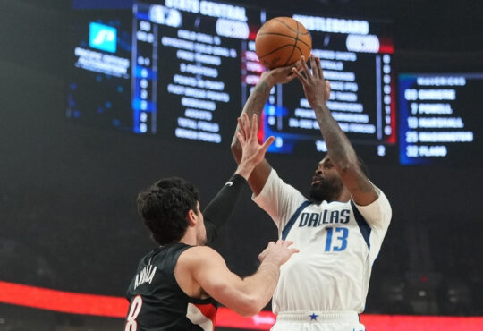 Naji Marshall #13 of the Dallas Mavericks takes a jumper over Deni Avdija #8 of the Portland Trail Blazers during an NBA game at the Moda Center.