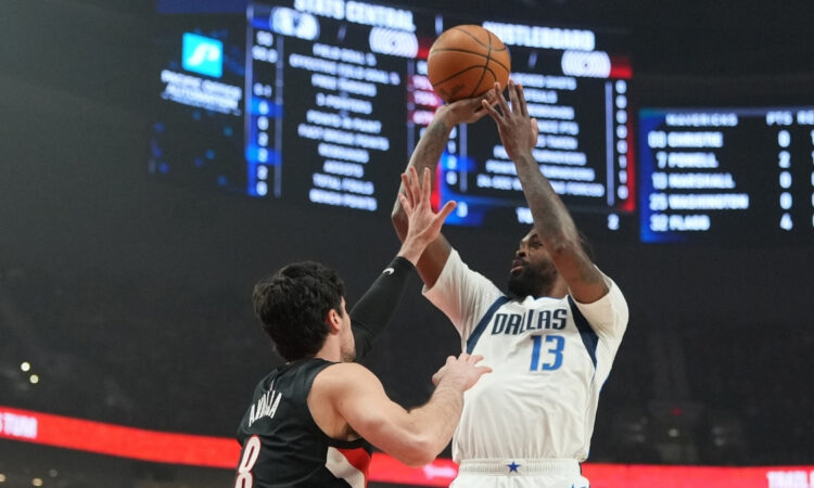 Naji Marshall #13 of the Dallas Mavericks takes a jumper over Deni Avdija #8 of the Portland Trail Blazers during an NBA game at the Moda Center.