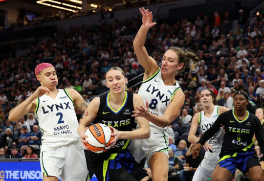 Paige Bueckers of the Dallas Wings drives to the basket against Alanna Smith and Natisha Hiedeman of the Minnesota Lynx.