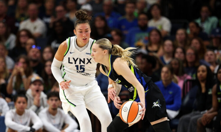 Paige Bueckers #5 of the Dallas Mavericks drives to the basket against Jessica Shepard #15 of the Minnesota Lynx at Target Center.