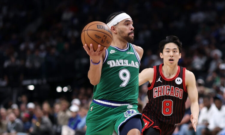 Ryan Nembhard #9 of the Dallas Mavericks drives past Yuki Kawamura #8 of the Chicago Bulls at American Airlines Center.