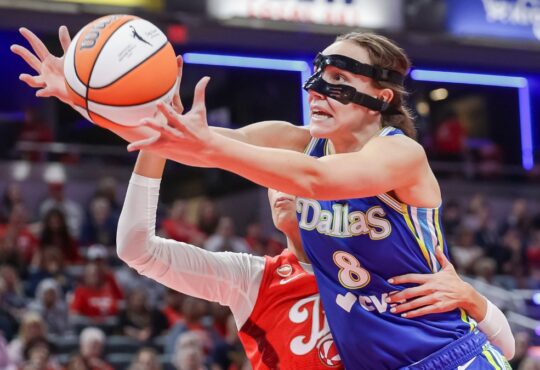 Alanna Smith (8) of the Dallas Wings reaches for a loose ball against Sophie Cunningham (8) of the Indiana Fever.