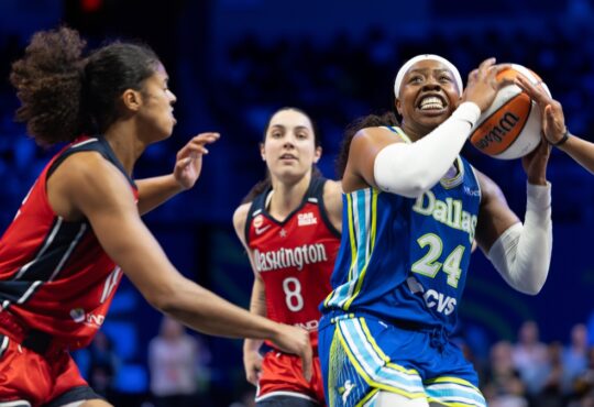 Arike Ogunbowale driving hard past a perimeter defender with her right hand during a regular-season WNBA game.