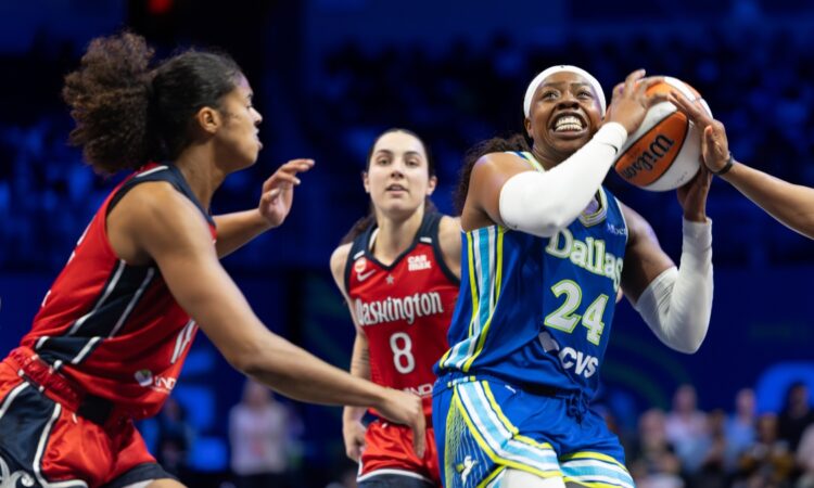 Arike Ogunbowale driving hard past a perimeter defender with her right hand during a regular-season WNBA game.