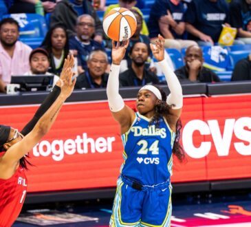 Arike Ogunbowale of the Dallas Wings rising for a contested jump shot over Allisha Gray of the Atlanta Dream.