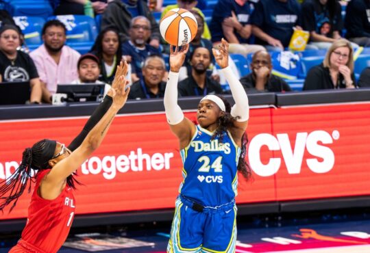 Arike Ogunbowale of the Dallas Wings rising for a contested jump shot over Allisha Gray of the Atlanta Dream.