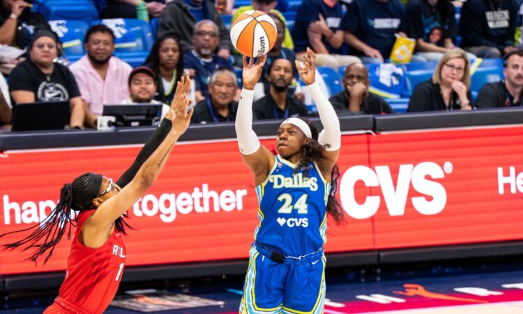 Arike Ogunbowale of the Dallas Wings rising for a contested jump shot over Allisha Gray of the Atlanta Dream.