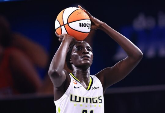 Forward Awak Kuier standing at the free-throw line, focusing on the rim with the ball balanced in her hands before launching her shot attempt.