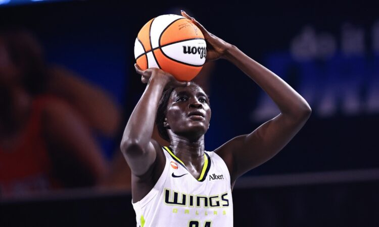 Forward Awak Kuier standing at the free-throw line, focusing on the rim with the ball balanced in her hands before launching her shot attempt.